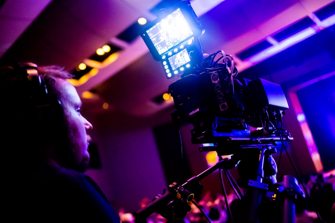 services-04 A professional cameraman operating a camera during a vibrant nightlife event indoors.