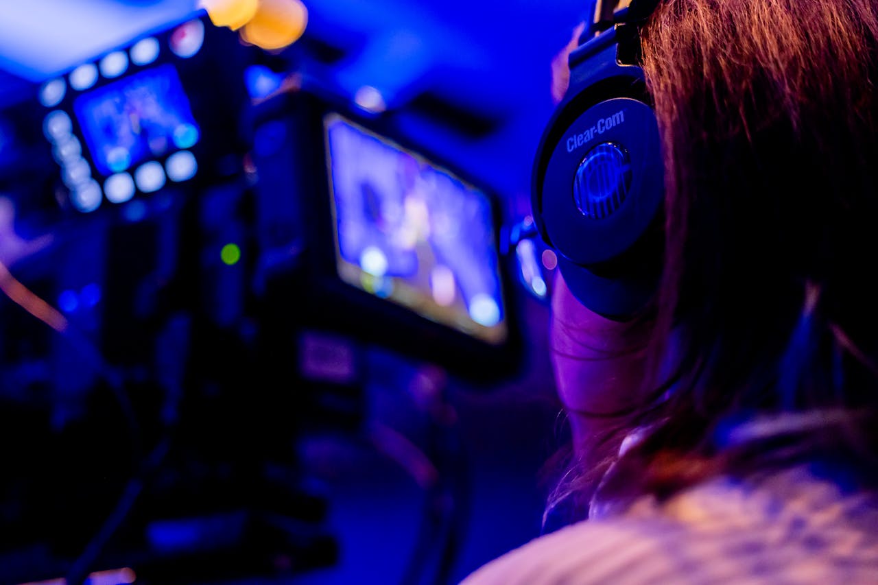 Crafting Captivating Headlines: Your awesome post title goes here A person wearing headphones operates a camera in a vibrant studio environment.