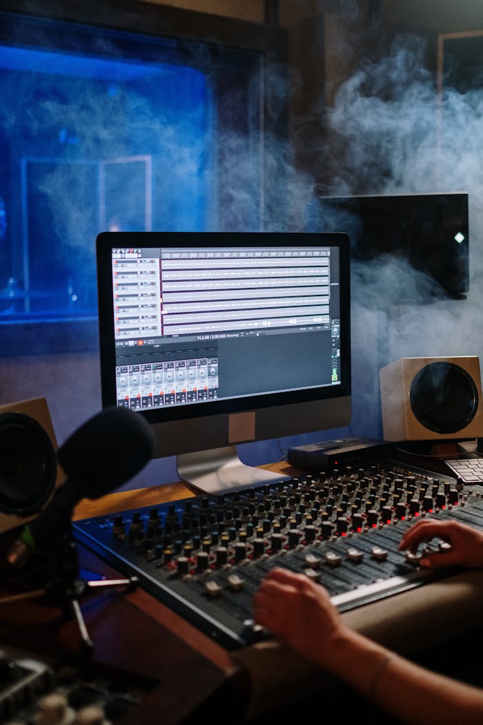 services-01 A modern music studio with audio mixer and computer screen displaying tracks.